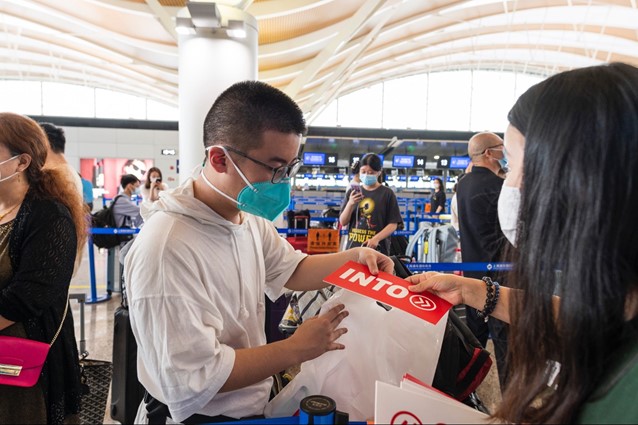 International student consults INTO staff member before boarding a charter flight from China to the UK.