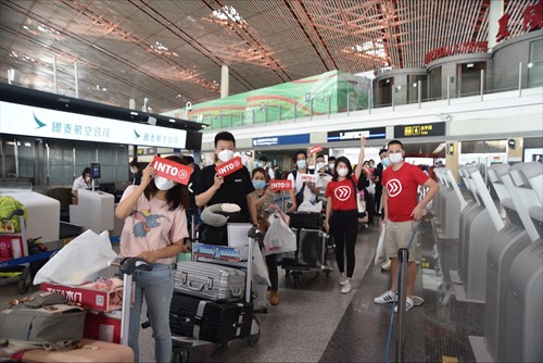 Chinese INTO students pose with INTO while waiting in line to check baggage in Hong Kong before flight to London, UK.